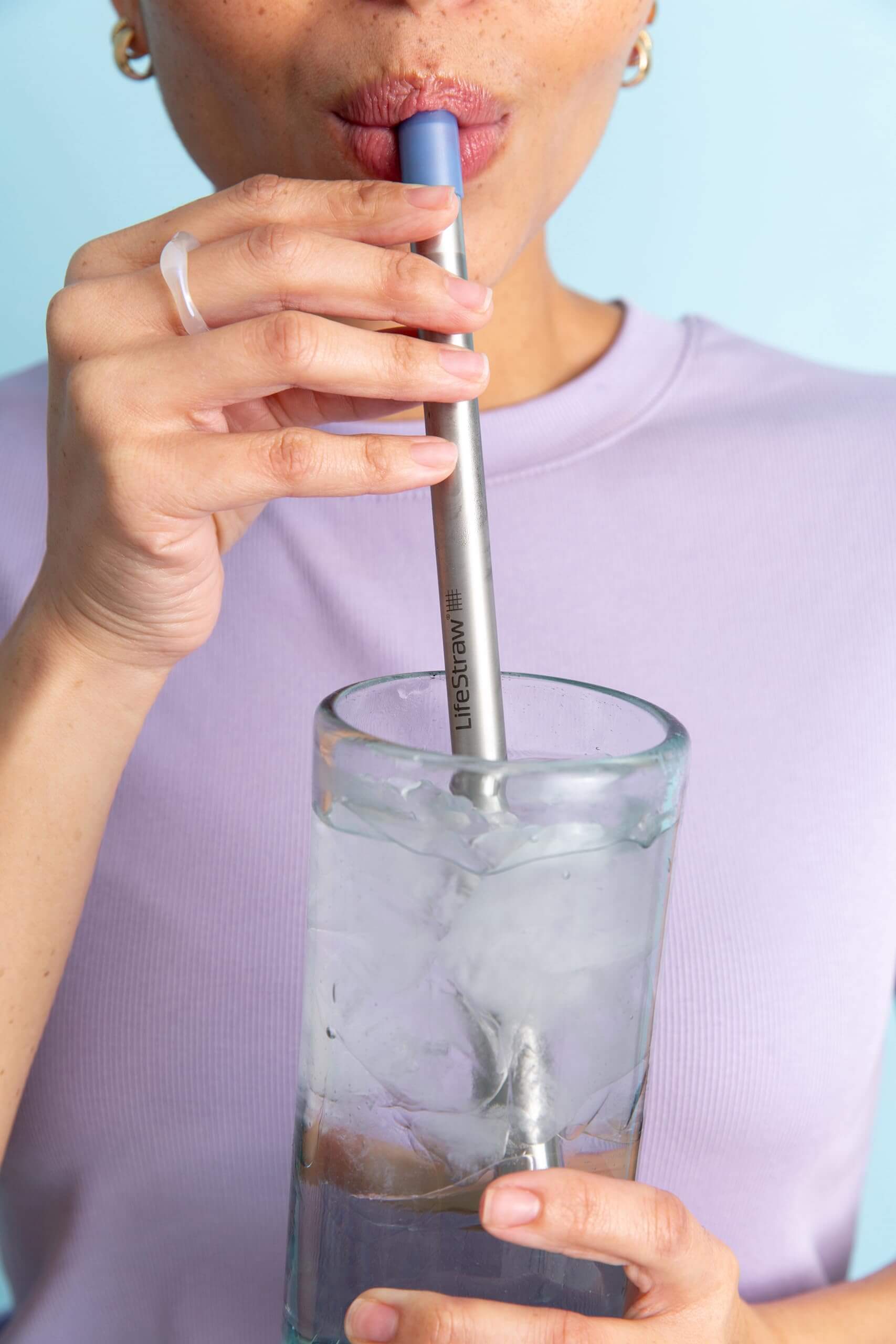 Hier ist der LifeStraw Sip im EInsatz - eine Dame trinkt aus einem Glas mit ihrem LifeStraw Sip, er eignet sich für Indoor und Outdoor Einsatz